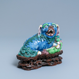 A Chinese porcelain 'Buddhist lion and cub' group on carved wooden stand, 19th C.