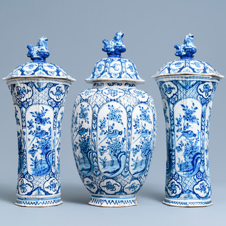 A Dutch Delft blue and white garniture of three vases and covers, 18th C.