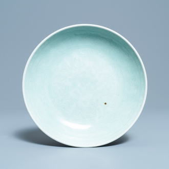 Een Chinese monochrome celadon schotel met onderglazuur decor, Qianlong