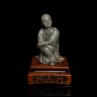 A Chinese Shoushan soapstone figure of a seated man, 18/19th C.