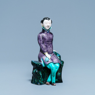 Een Chinese polychrome porseleinen figuur van een zittende dame, 19/20e eeuw