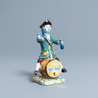 Een polychrome Delftse figuur van een wijndrinker op ton met inscriptie 'Rood Wyn', 18e eeuw