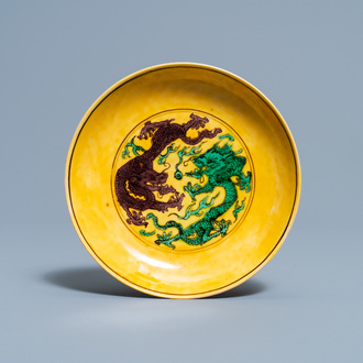 Une coupe en porcelaine de Chine à décor de dragons en vert et aubergine sur fond jaune, marque et époque de Kangxi