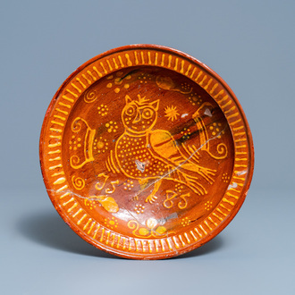 A Dutch slip-decorated pottery dish with an owl, dated 1585