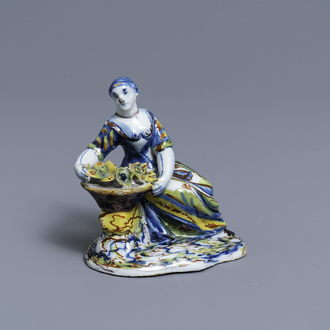 A polychrome Dutch Delft figure of a lady selling flowers, 18th C.