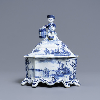 A Dutch Delft blue and white tobacco box and cover with a boy near a barrel, 18th C.