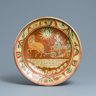 A German slip-decorated inscribed pottery dish with a ploughing farmer, Lower Rhine region, 2nd half 18th C.