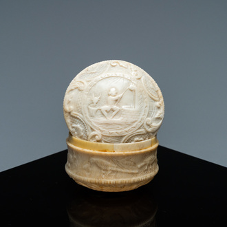 An ivory box and cover with a boy sitting by a water well, 18th C.
