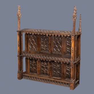 A carved oak shelf with pinnacles and stylised flowers and carved panels, 15th C. and later