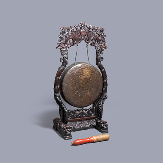 A Chinese bronze gong set in a carved wooden stand, 19th C.