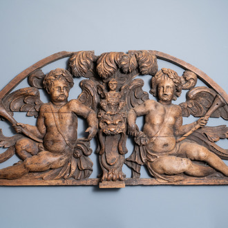 A reticulated carved oak fronton with two winged cherubs holding a horn, France, 17th C.