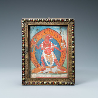 A Tibetan thangka in inlaid gilt brass frame, 19th C.