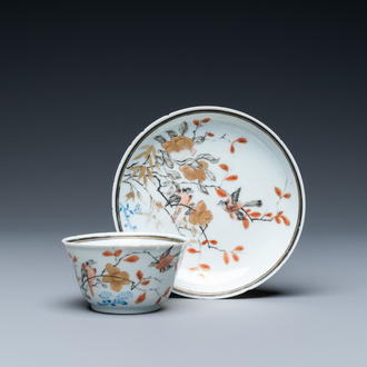 A Chinese grisaille, iron-red and gilt cup and saucer with birds near blossoming branches, Yongzheng