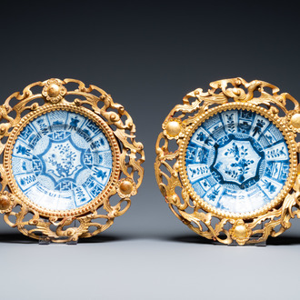 A pair of Chinese blue and white plates in Chinese gilded wooden frames, Kangxi and 19th C.