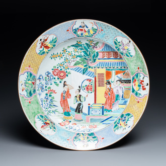 Un grand plat en porcelaine de Chine famille rose à décor de figures devant un temple, Yongzheng