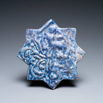 A molded Ilkhanid Lajvardina blue-ground star-shaped tile, Iran, 13/14th C.