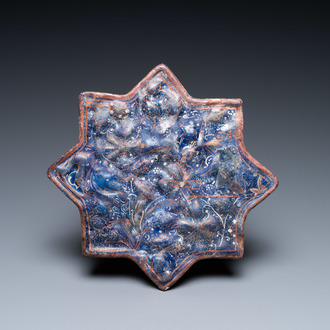 A molded Ilkhanid Lajvardina blue-ground star-shaped tile, Iran, 13/14th C.