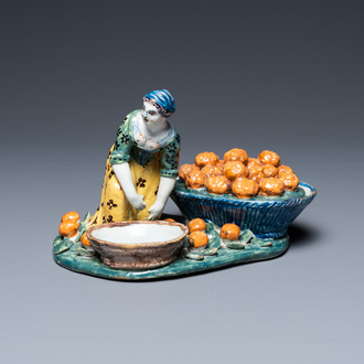 A polychrome Dutch Delft figure of a fruit seller with a small tureen, 18th C.