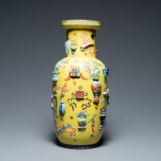 A Chinese yellow-ground famille rose rouleau vase with applied 'antiquities' design, 19th C.