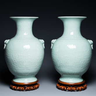 Een paar Chinese monochrome celadon vazen met onderglazuur decor op houten sokkels, Qianlong merk, 18/19e eeuw