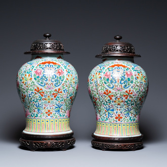 A pair of Chinese famille rose vases with wooden covers and stands, 19th C.