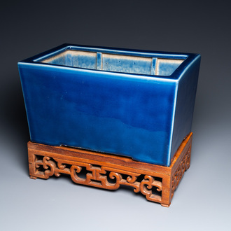 A Chinese rectangular blue-glazed jardinière on wooden stand, 19th C.