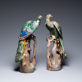 A pair of large Chinese polychrome pottery peacocks on tree trunks, Shiwan, 19th C.