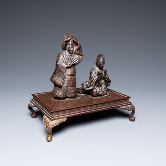 A Japanese bronze okimono depicting two figures on a base, Meiji, 19th C.