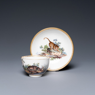 Une tasse et soucoupe en porcelaine d'Ansbach surdécorée à La Haye à décor d'un léopard et d'un loutre, 18ème