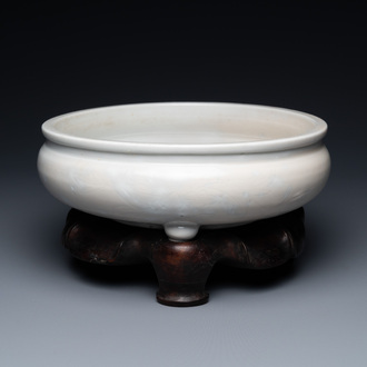 A Chinese Dehua blanc de Chine tripod censer with incised floral design on wooden stand, Kangxi