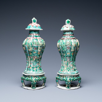 A pair of Chinese verte biscuit vases and covers on stands, Kangxi