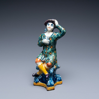 A polychrome Dutch Delft figure of a seated man, 18th C.