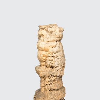 A large stalagmite specimen on a square wooden base