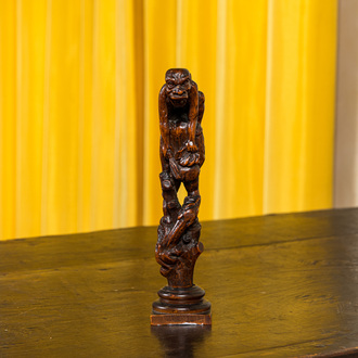 A wooden group with a pooping figure, 18/19th C.