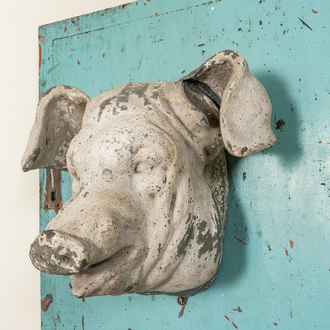 A white-patinated pig's head mounted on a turquoise-ground cabinet door, 20th C.
