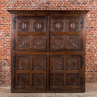 A rare large Flemish oak four-door cupboard with carved X-panels and wrought iron mounts, 1st half 16th C.