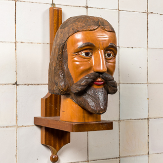 A large polychromed carved wooden head of a bearded man on a wooden console base, 19/20th C.
