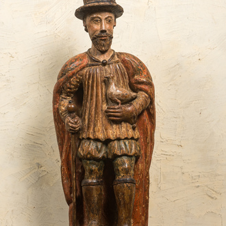 A Spanish polychrome walnut figure of a nobleman with a dove, 16/17th C.