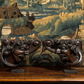 A pair of carved oak reliefs with devils' heads, 17th C.