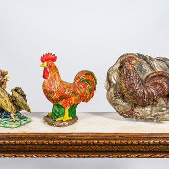 Two polychrome roosters in terracotta and composite stone and a wooden relief, 19/20th C.