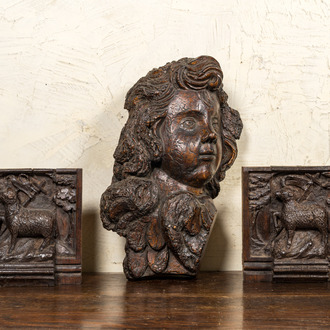 A carved oak cherub's head and a pair of 'Lamb of God' panels, 17th C.