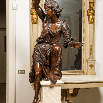 A large walnut figure of an angel, Flanders, 17th C., on a later stand