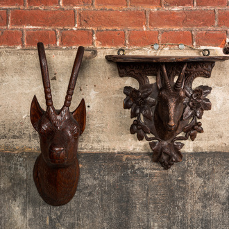 A carved wooden 'Black Forest' goat's head console and a carved oak head of a buck, Switzerland and/or Germany, 19/20th C.