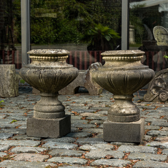 A pair of stone garden vases on square bases, one dated 1873