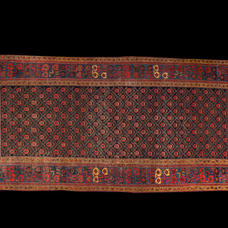 An Oriental rug with geometric motifs and floral design, wool on cotton, 20th C.