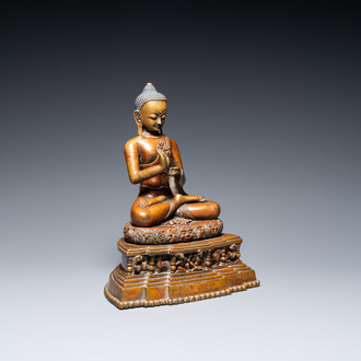 A large Tibetan brass and copper Buddha on throne, probably 16th C.