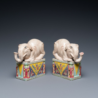 A pair of Chinese famille rose elephants on stands, 20th C.