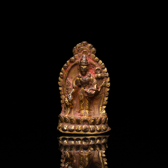 Een vergulde bronzen miniatuur Boeddha met sporen van rode lak, Tibet of Nepal, 15/16 eeuw