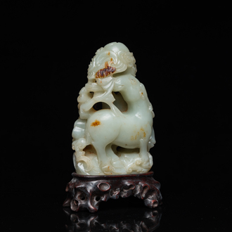 A Chinese celadon and russet jade ram sculpture on wooden stand, 19th C.