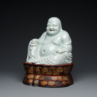 A Chinese blanc de Chine Buddha on lacquered and gilded wooden 'lotus' stand, Qianlong/Jiaqing